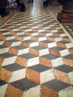 the floor is made up of orange and white checkerboard tiles, with columns in the background