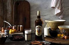 a bottle of beer sitting on top of a table next to bowls and plates filled with food