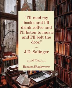 a table with books and a laptop on it in front of a bookcase filled with books