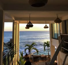 an ocean view from the inside of a house with stairs leading up to it's second floor