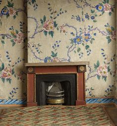 an old fashioned fireplace in a room with floral wallpaper