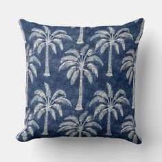 a blue pillow with white palm trees on it