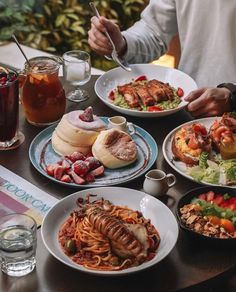 a table topped with plates of food and drinks