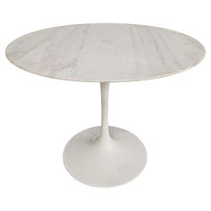 an oval marble dining table with a white base and round top, viewed from the front