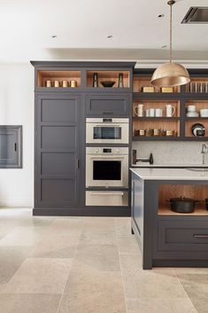 a kitchen with gray cabinets and white counter tops