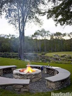 an outdoor fire pit with benches around it