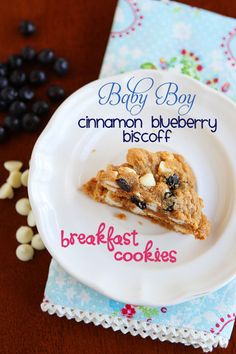 a white plate topped with a slice of blueberry crumbled cookie next to a cup of coffee