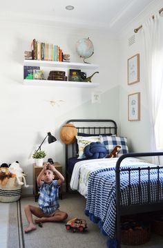 a young boy sitting on the floor in his bedroom