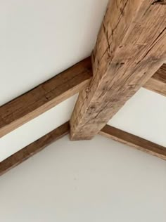 an unfinished ceiling with wood beams and white walls