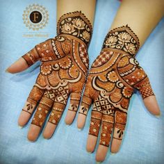 two hands with henna designs on them