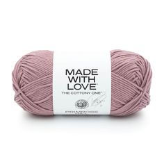 a ball of yarn with the words made with love written on it in white and pink