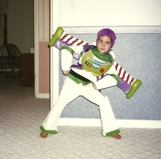 a young boy dressed up as buzz lightyear from toy story with his arms outstretched