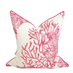 a pink and white pillow with corals on it