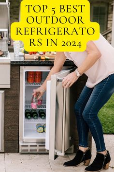 a woman is opening the refrigerator door for her food and drink in the back yard