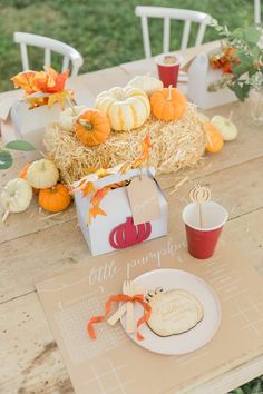 the table is set with pumpkins, hay and other items for fall dinnereon