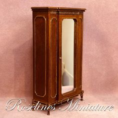 an antique wooden armoire with mirror on top