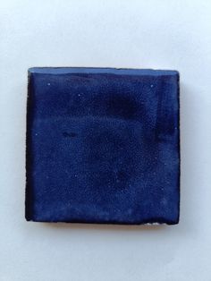 a blue square shaped object sitting on top of a white surface