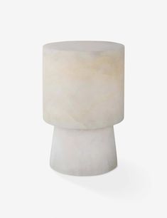 a small white vase sitting on top of a table