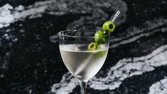 a martini glass with an olive garnish on the rim