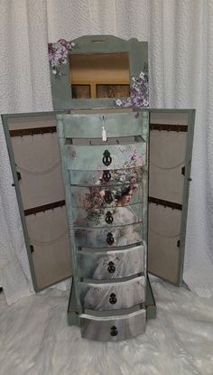 an old dresser with drawers is sitting on the floor in front of a white curtain