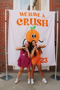 two girls are standing in front of a banner that says we have a crush on it