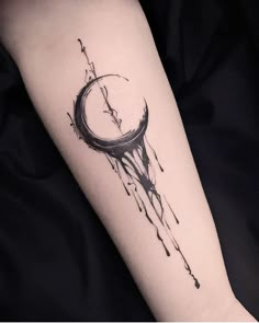 a black and white photo of a clock tattoo on the right arm with watercolor paint splatters