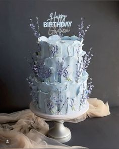 a blue and white cake with lavender flowers on it