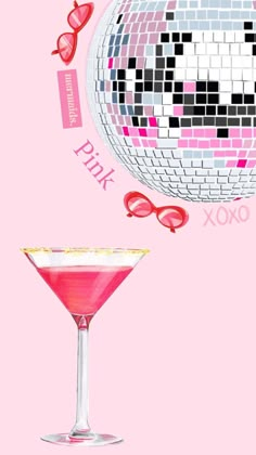 a pink cocktail in a martini glass next to a disco ball with hearts on it