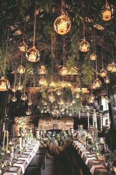 an indoor dining area with hanging lights and greenery