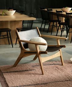 a chair with a sheep pillow sitting on top of it in front of a table