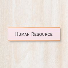 a pink sign that says human resources on the side of a wooden wall with black lettering