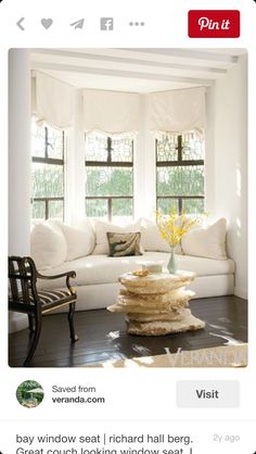 a living room filled with white furniture and lots of windows in it's walls