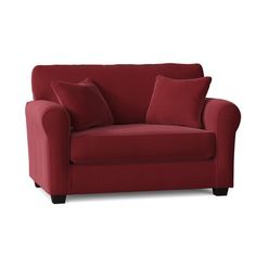 a red couch with two pillows on it