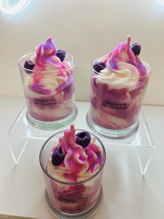 three desserts in glass cups with fruit on top