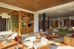 a living room filled with lots of furniture and wooden shelves on the wall next to windows