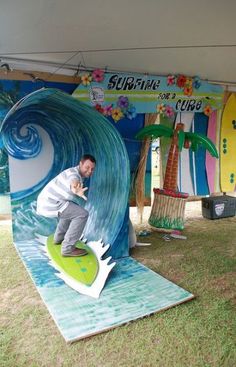 a man riding a surfboard on top of a fake wave in front of a tent