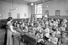 an old black and white photo of a classroom full of children