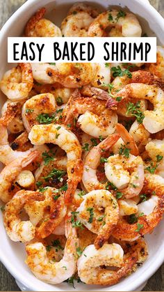 a white bowl filled with shrimp and parsley breadcrumbs on top of a wooden table