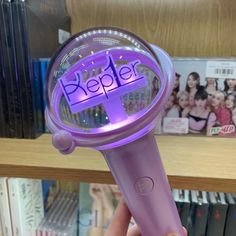 a person holding a purple hair dryer with the word keeper on it's side