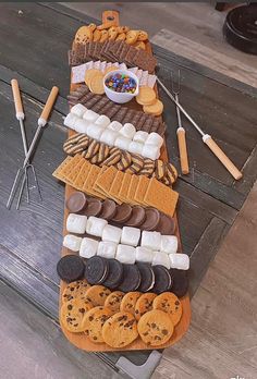 a table topped with lots of different types of cookies and marshmallows on top of each other