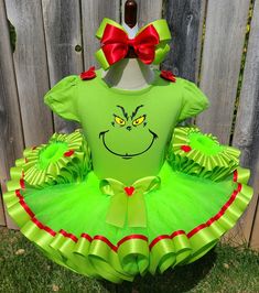 a green grin face tutule dress with red bows on the head and feet