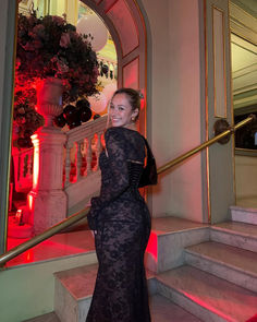 a woman in a black dress standing on stairs