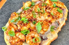 a pizza with shrimp and basil on it