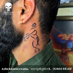 a man with a tattoo on his neck and behind his ear is looking into the distance