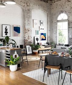 an industrial style living room with exposed brick walls and wood flooring is furnished with modern furniture