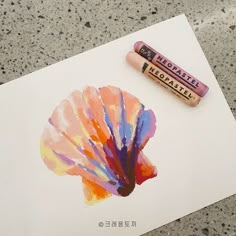 a pencil and crayon are sitting on top of a piece of art paper