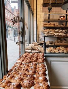 breads and pastries are on display in a bakery