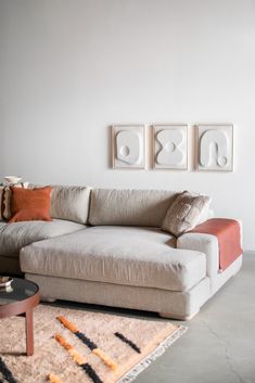 a living room with a couch, coffee table and pictures on the wall