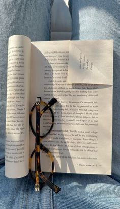 an open book with reading glasses on it