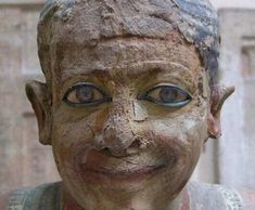 an old statue with blue eyes and brown hair